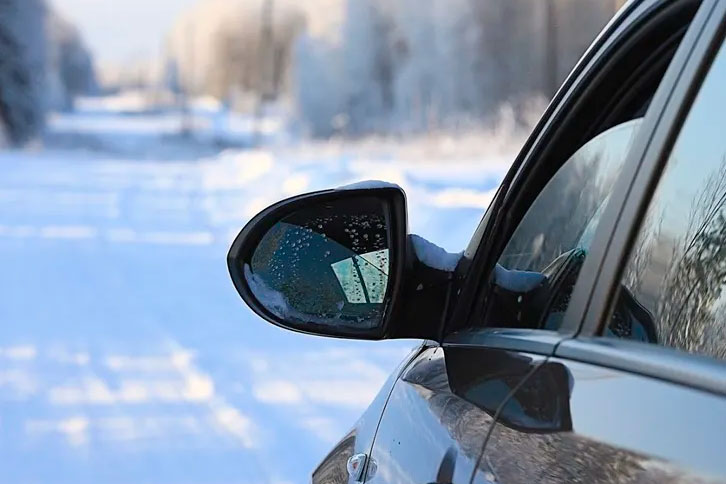 sedan car with broken mirror in winter driving