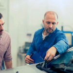 auto glass technician explaining the problem to customer