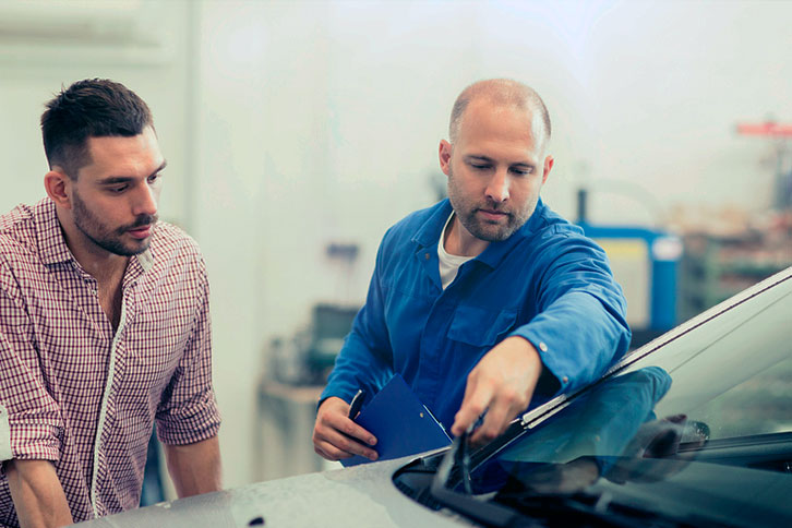 auto glass technician explaining the problem to customer