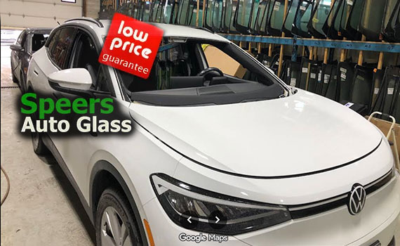 white Volkswagen Passat sedan needs front windshield replacement in Speers Oakville shop